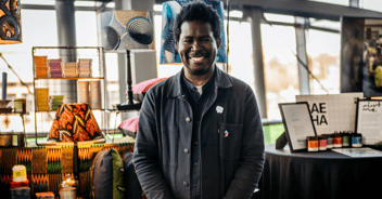 Baesha founder stands in front of his expo stand at an event