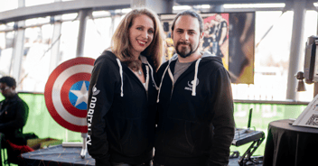 Orbital FX founders stand in front of Captain America's shield prop on an exhibition stand